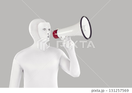 Man disguised in a white mask and bodysuit makes an announcement through a megaphone 131257569