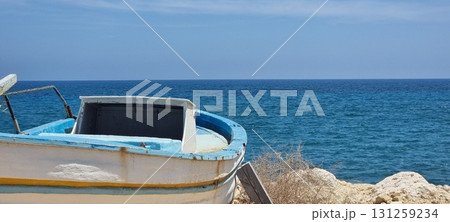 Old Fishing Boat on Rocky Mediterranean Coast, Cyprus Old Fishing Boat on Rocky Mediterranean Coast, Cyprus 131259234