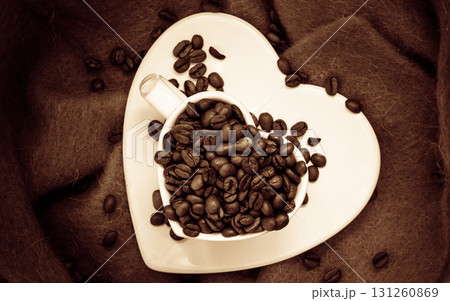 Heart shaped cup with coffee beans on brown 131260869