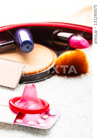 Pills, condom and cosmetics in handbag. Pills, condom and cosmetics in handbag. 131260875