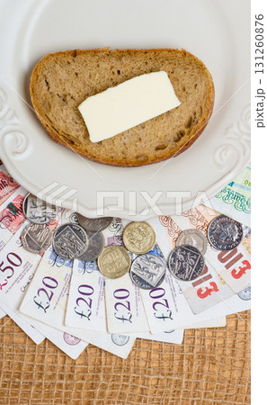 British money, piece of bread on plate. Food budget. British money, piece of bread on plate. Food budget. 131260876