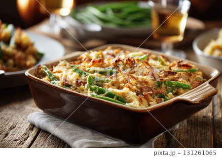 Green bean casserole in a baking dish, placed on rustic wooden table. Thanksgiving dinner Green bean casserole in a baking dish, placed on rustic wooden table. Thanksgiving dinner 131261065
