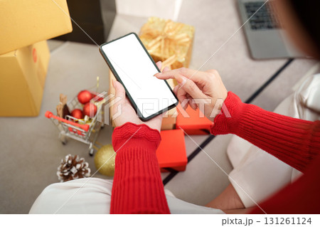Christmas shopping. Woman using smartphone to browse gifts during holiday season. Christmas shopping. Woman using smartphone to browse gifts during holiday season. 131261124