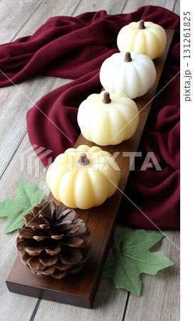 Elegant display of candles with colorful pumpkins and pinecones adds a cozy touch to the autumn season in a bright setting 131261825