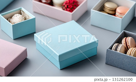 A person holds a beautifully wrapped box filled with colorful macarons, showcasing a warm and inviting atmosphere 131262100