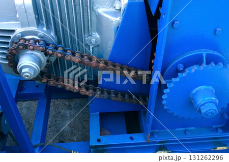 Engine of woodworking machine with chain rotating between gear wheels on plant. Engine of woodworking machine with chain rotating between gear wheels on plant. 131262296