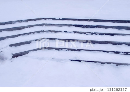 Steps in the snow at entrance to the building in winter, slippery stairs. Steps in the snow at entrance to the building in winter, slippery stairs. 131262337