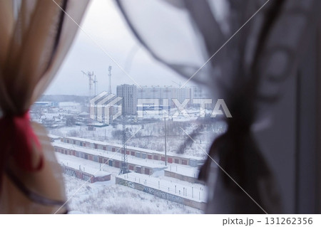 View of the neighborhood under construction and rows of garages from the apartment window in the high-rise building. View of the neighborhood under construction and rows of garages from the apartment window in the high-rise building. 131262356