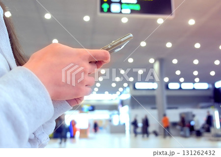 Woman check-in online registration on her mobile phone in airport hall, hands with smartphone close-up. 131262432