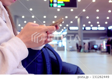 Woman check-in online registration on her mobile phone in airport hall, hands with smartphone close-up. 131262449