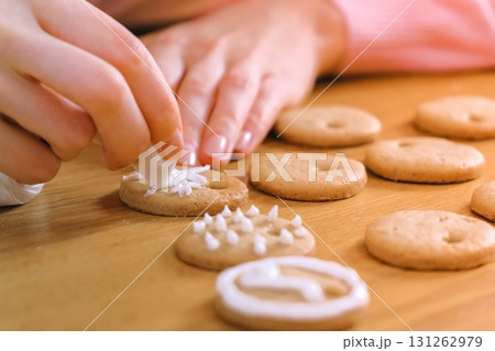 Woman's hands decorate christmas cookies with sugar sweet icing. Woman's hands decorate christmas cookies with sugar sweet icing. 131262979