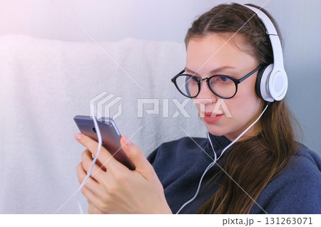 Woman listens music in headphones on smartphone and sings a song. 131263071