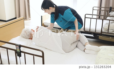 高齢者の体位変換を行うアジア人介護士 高齢者の体位変換を行うアジア人介護士 131263204