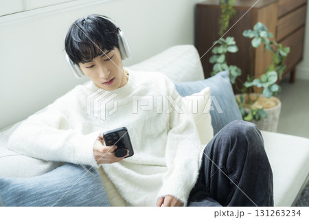 リビングで音楽を聴く男性 リビングで音楽を聴く男性 131263234