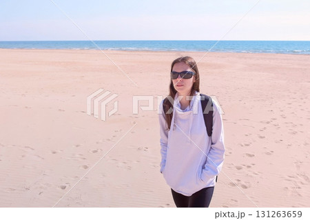 Woman tourist walks on sea sand beach off-season travel outdoors activities. 131263659