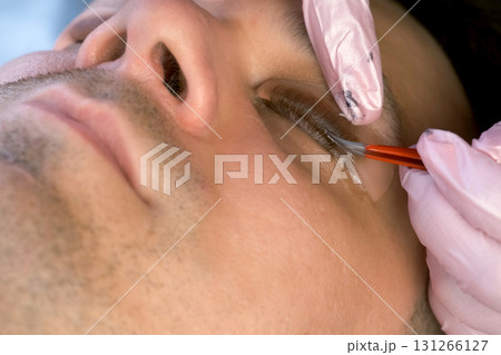 Cosmetologist bending lashes with needle into curlers, lift eyelashes laminaton. 131266127