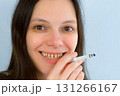 Young woman with yellow bad teeth smoking a cigarrete smiling looking at camera. 131266167