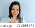Young woman with yellow bad teeth pouring lemonade in glass and smiling. 131266172