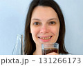 Young woman with yellow bad teeth pouring lemonade in glass and smiling. 131266173