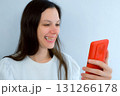 Young smiling woman with yellow bad teeth calling by video on mobile phone. 131266178