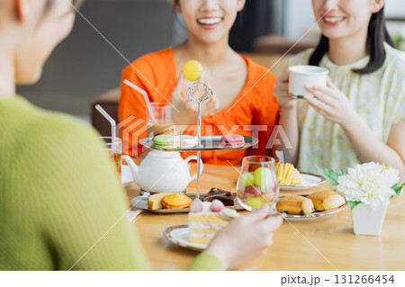 カフェでアフタヌーンティーを楽しむ若い女性 カフェでアフタヌーンティーを楽しむ若い女性 131266454