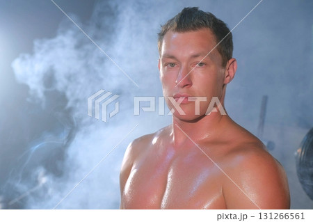 Portrait professional muscular athletic man bodybuilder sitting on bench in gym. 131266561