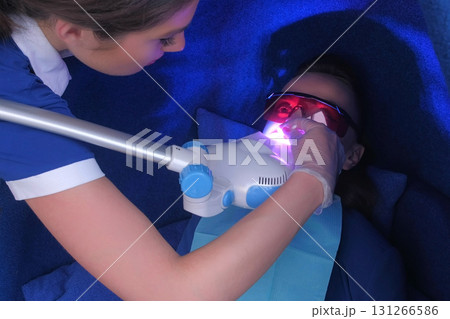 LED whitening beauty cosmetic procedure for woman's teeth in stomatology. 131266586