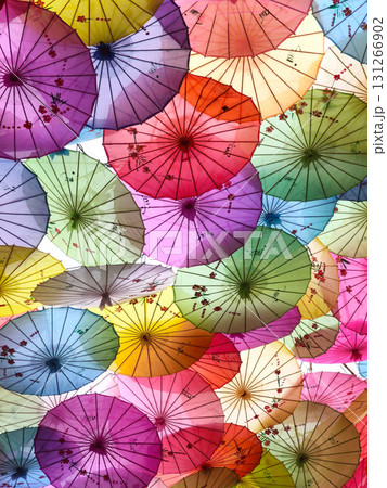Colorful Chinese umbrellas hanging together creating a beautiful, vibrant overhead display. 131266902