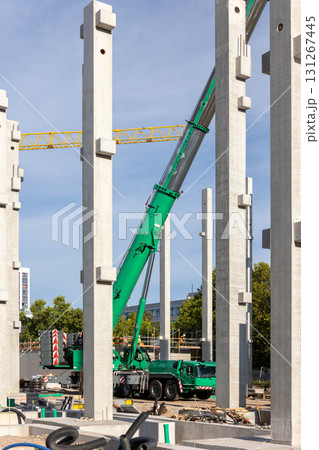 Extra heavy weight load mobile boom crane working modern city construction site with many concrete pillars blue sky background. Telescopic boom lifting equipment rental service. Industrial machinery Extra heavy weight load mobile boom crane working modern city construction site with many concrete pillars blue sky background. Telescopic boom lifting equipment rental service. Industrial machinery 131267445