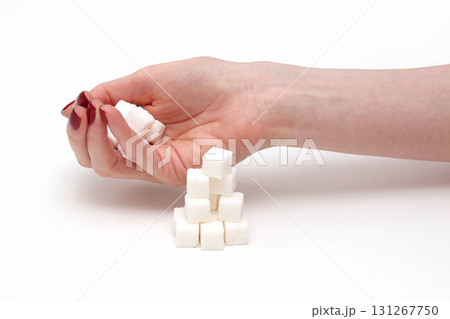 Hand with white sugar cubes 131267750