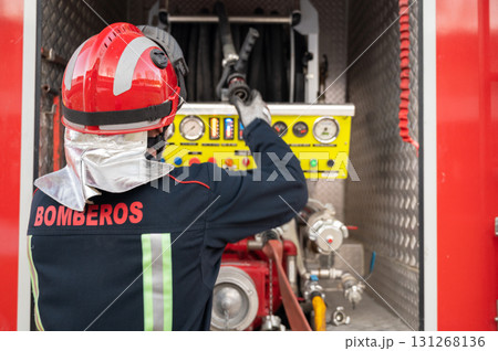 Unrecognizable Firefighter check and maintenance equipment near fire truck.  131268136