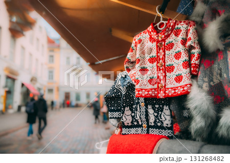 Various Colorful Knitted Traditional European Warm Clothes - Sweaters At Winter Christmas Market. Christmas Winter Souvenir From Europe Various Colorful Knitted Traditional European Warm Clothes - Sweaters At Winter Christmas Market. Christmas Winter Souvenir From Europe 131268482