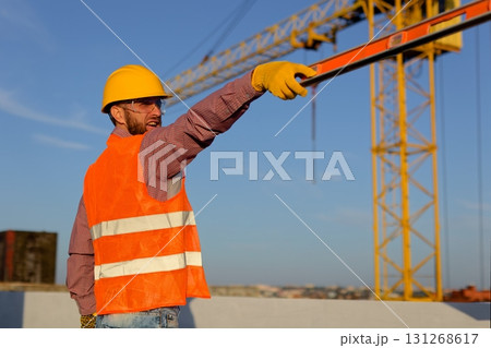 Construction manager and engineer discussing building project on site with crane in background 131268617