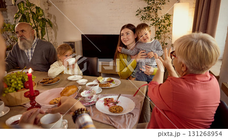 Family at festive table with children laughing and sharing food Family at festive table with children laughing and sharing food 131268954