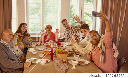 Family taking cheerful selfie together during cozy holiday celebration 131268982