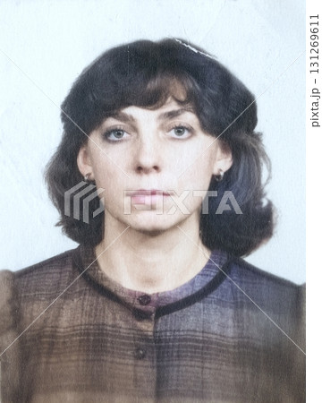 Vintage portrait of a young, serious-looking woman with curly brown hair. Retro photo, 1984. Vintage portrait of a young, serious-looking woman with curly brown hair. Retro photo, 1984. 131269611