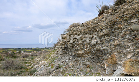 Unique geological formation reveals stones and soil against a beautiful coastal 131270078