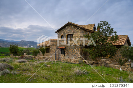 Stone house abandoned in a tranquil countryside setting with mountains 131270344