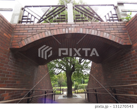 赤レンガのトンネルを抜けると緑が広がる公園の風景 131270543