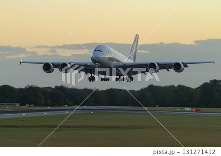 Airplane takes off from the runway against a vibrant sunset sky with clouds 131271412