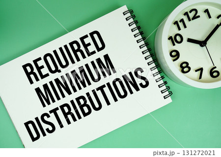 Required Minimum Distribution text with alarm clock flat lay on green background Required Minimum Distribution text with alarm clock flat lay on green background 131272021