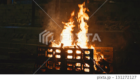 Varanasi, Uttar Pradesh, India. Fire burn faster during a funeral cremation ceremony on Harishchandra Ghat. Harishchandra Ghat is one of the only two ghats serving as cremation sites along Ganges Varanasi, Uttar Pradesh, India. Fire burn faster during a funeral cremation ceremony on Harishchandra Ghat. Harishchandra Ghat is one of the only two ghats serving as cremation sites along Ganges 131272127