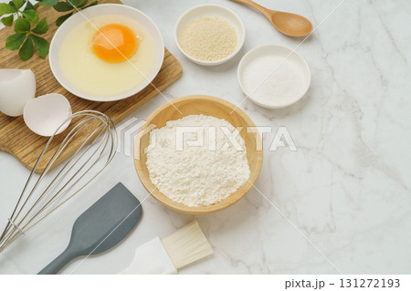 料理・お菓子づくりのイメージ(小麦粉・卵・塩・きび砂糖)・白い大理石背景 131272193