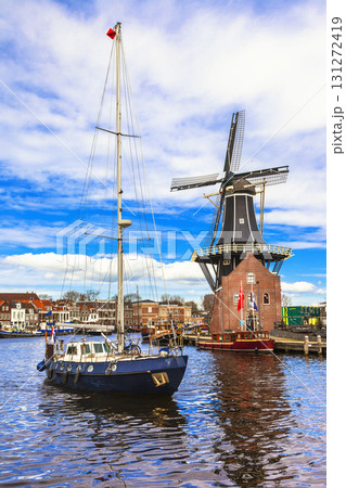 Holland, Haarlem' canals. view with traditional windmill and sailboat Holland, Haarlem' canals. view with traditional windmill and sailboat 131272419