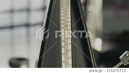 Close Up of Classic Wooden Metronome with Swinging Pendulum 131272713