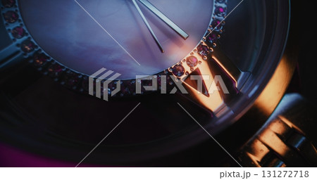 Close Up of Elegant Wristwatch with Gemstone Bezel and Metallic Bracelet Showing Precise Time 131272718