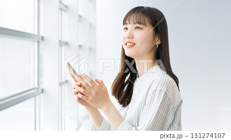 スマートフォンを使う笑顔の女性・ビジネスウーマン 131274107