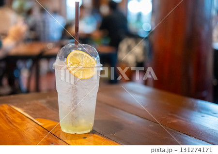 A glass of honey lemon soda on the wooden table, with bokeh background of the restaurant A glass of honey lemon soda on the wooden table, with bokeh background of the restaurant 131274171