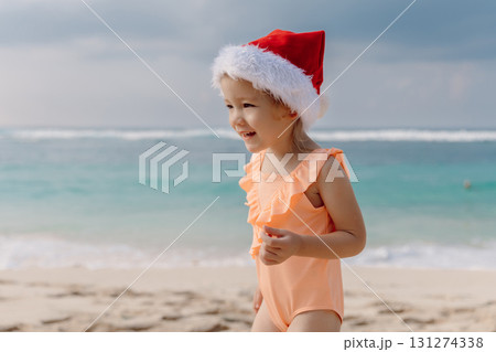 Little child girl in tropical beach with Christmas hat. Little child girl in tropical beach with Christmas hat. 131274338