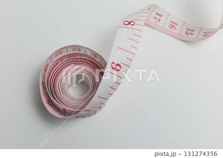 A measuring tape is displayed on a white A measuring tape is displayed on a white 131274356